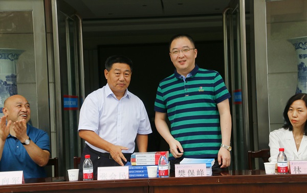 新乡市牧野区税务局党委书记、局长樊保峰向乐鱼官网党委书记张会民赠送税法知识书籍.jpg